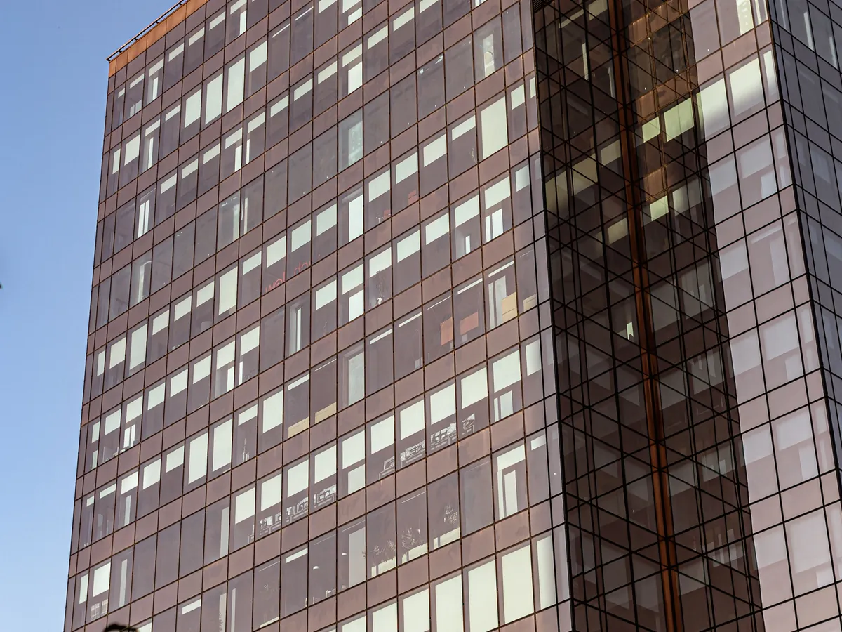Glass-clad commercial office tower catching evening light, representing commercial mortgage financing.