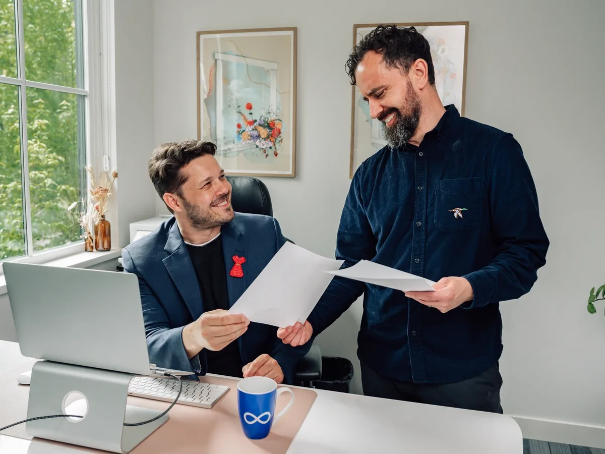 Two business professionals reviewing documents together in a bright modern office, representing collaborative business consulting.